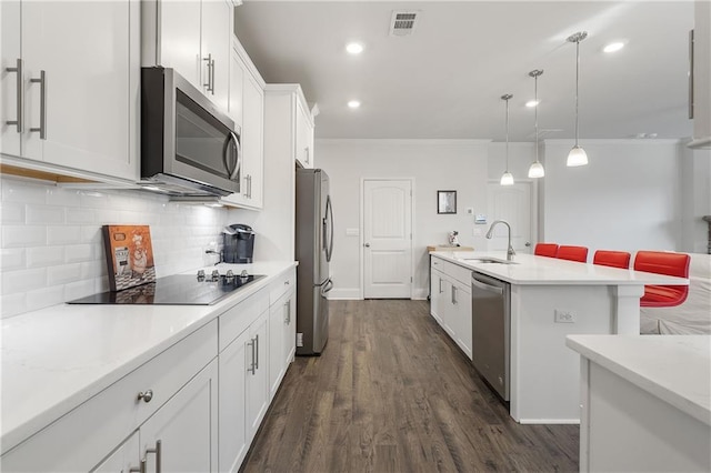 kitchen featuring tasteful backsplash, appliances with stainless steel finishes, light countertops, and a sink