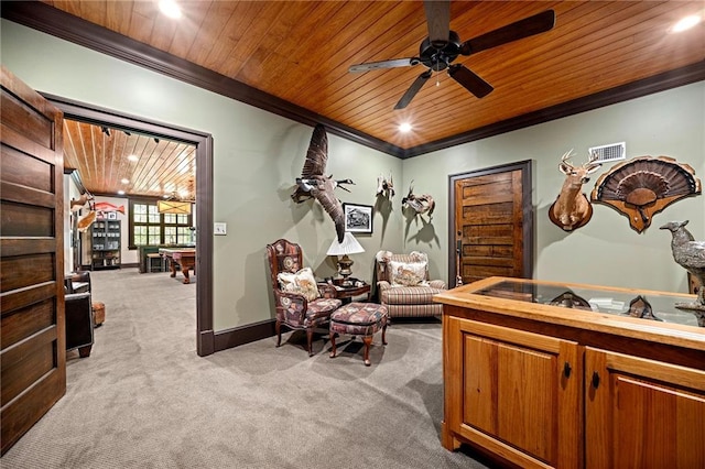 sitting room with ornamental molding, wooden ceiling, ceiling fan, and carpet flooring