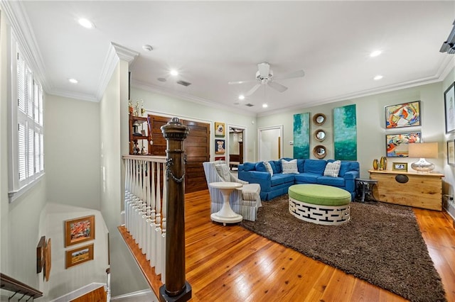 living room featuring wood-type flooring, ceiling fan, and crown molding