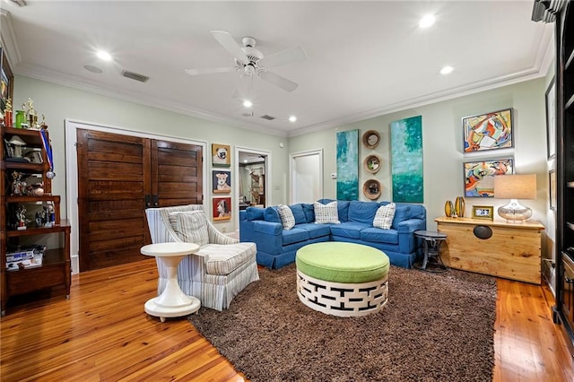 living room with ceiling fan, light hardwood / wood-style floors, and ornamental molding