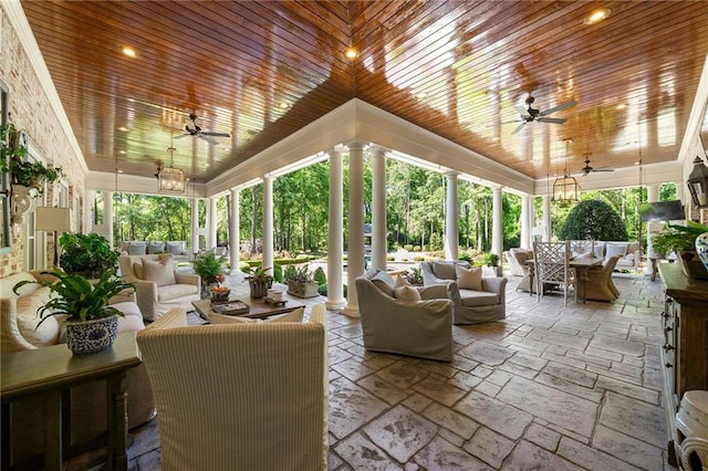 exterior space featuring wooden ceiling, ornate columns, and ceiling fan