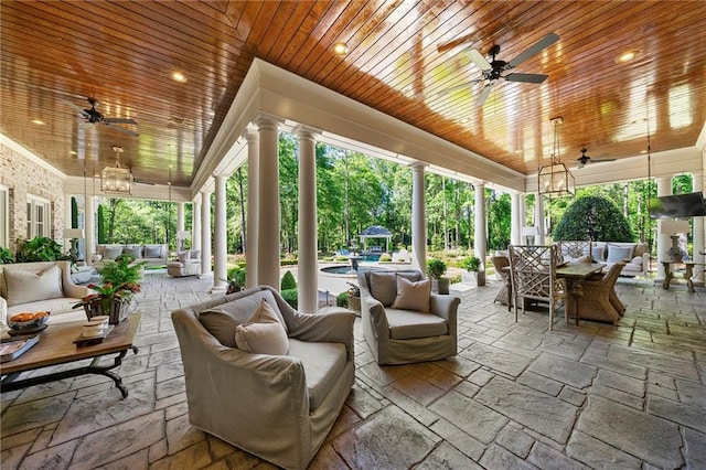 sunroom featuring wooden ceiling, ornate columns, and ceiling fan