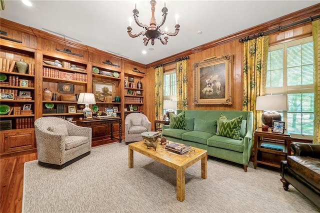 living area featuring a wealth of natural light, crown molding, wood-type flooring, and a notable chandelier