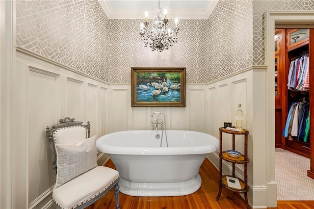 bathroom with a bath, crown molding, and an inviting chandelier