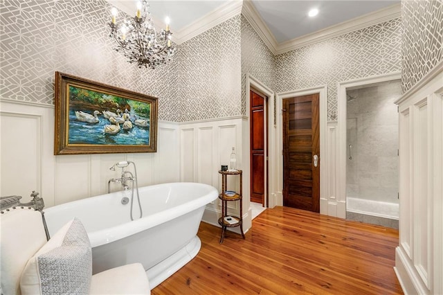 bathroom with hardwood / wood-style floors, crown molding, a bath, and a chandelier