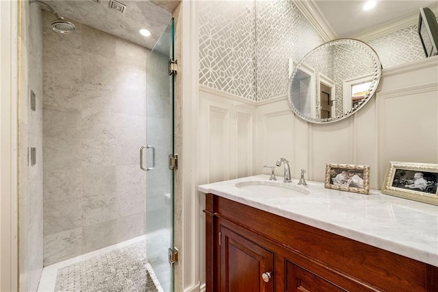 bathroom with ornamental molding, vanity, and a shower with door