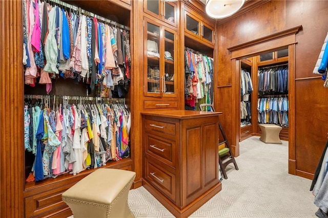 walk in closet with light carpet