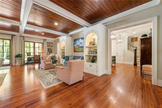 living room featuring wood-type flooring, ornamental molding, built in shelves, beam ceiling, and wood ceiling