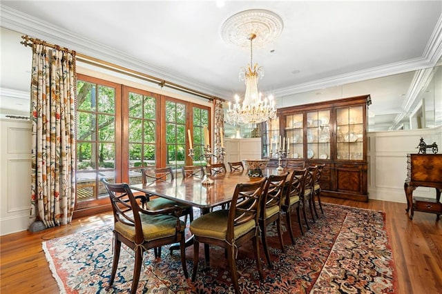 dining area featuring a chandelier, ornamental molding, and hardwood / wood-style flooring