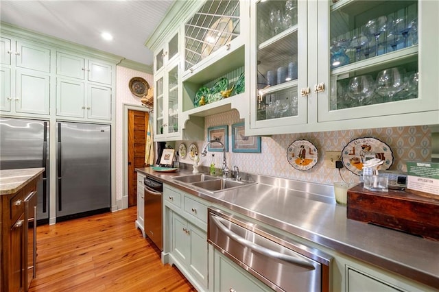 kitchen with stainless steel counters, light hardwood / wood-style flooring, backsplash, stainless steel appliances, and sink