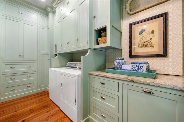 washroom featuring light hardwood / wood-style floors, cabinets, and separate washer and dryer