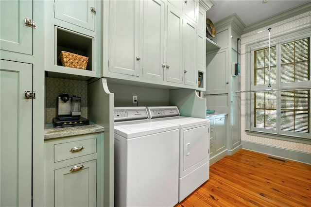 washroom featuring cabinets, washer and dryer, and light wood-type flooring