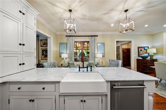 kitchen featuring sink, dishwasher, decorative light fixtures, wood-type flooring, and light stone countertops