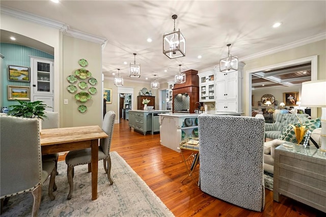 interior space featuring beamed ceiling, wood-type flooring, crown molding, and coffered ceiling