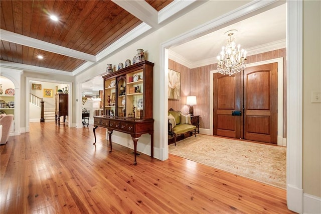 tiled entryway featuring wood ceiling, beam ceiling, and a chandelier