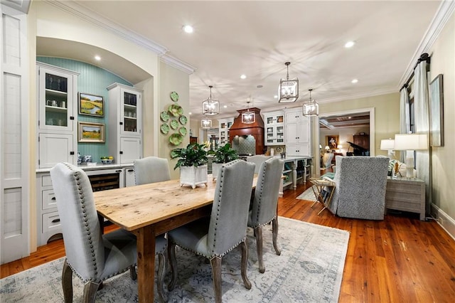 dining area featuring hardwood / wood-style floors, a notable chandelier, and crown molding