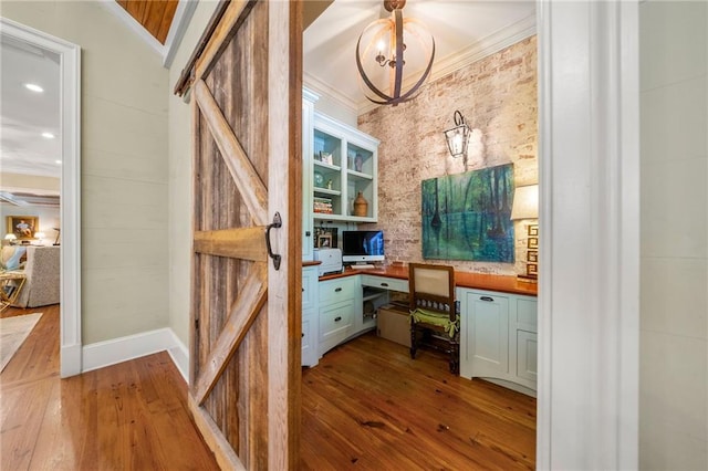 hallway with hardwood / wood-style flooring, ornamental molding, and built in features