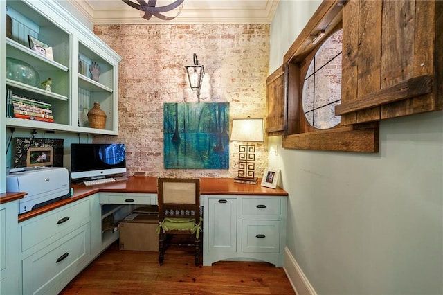 office featuring ornamental molding, dark hardwood / wood-style flooring, and built in desk