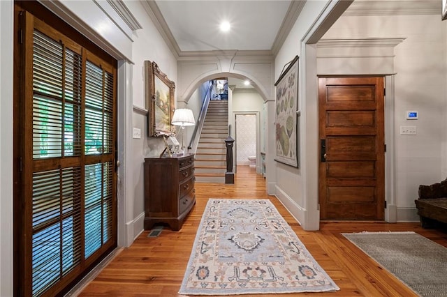 foyer entrance featuring wood-type flooring and crown molding