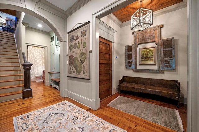 hallway featuring a notable chandelier, crown molding, and hardwood / wood-style flooring