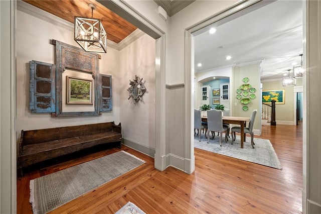 interior space featuring ornamental molding, a notable chandelier, and hardwood / wood-style flooring