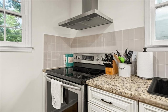 1649 Beecher St SW, Atlanta, GA 30310 - kitchen featuring stainless steel range with electric cooktop, wall chimney range hood, decorative backsplash, and white cabinetry