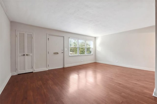 empty room with baseboards and wood finished floors