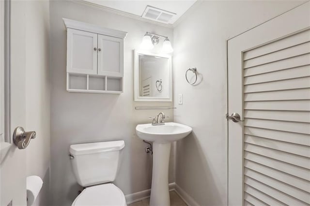 half bath with toilet, visible vents, and a sink