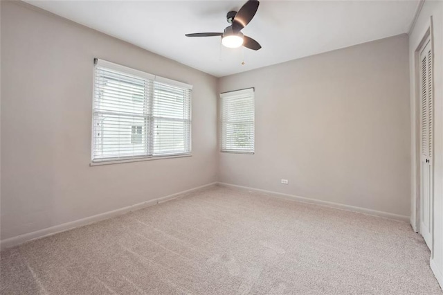 unfurnished bedroom featuring a closet, light carpet, baseboards, and a ceiling fan