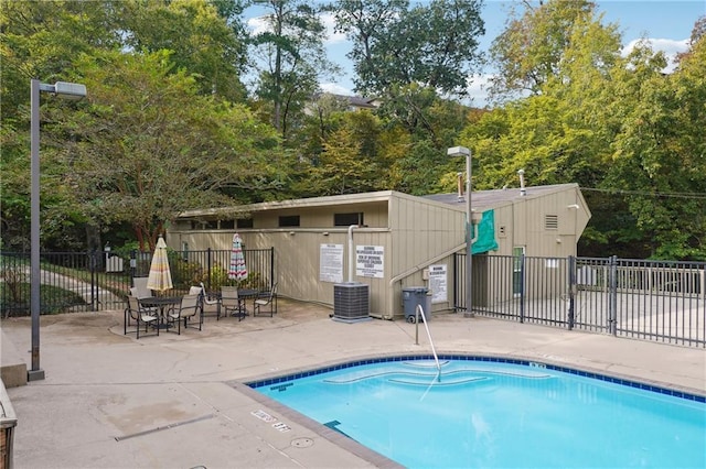 community pool with central air condition unit, a patio, and fence