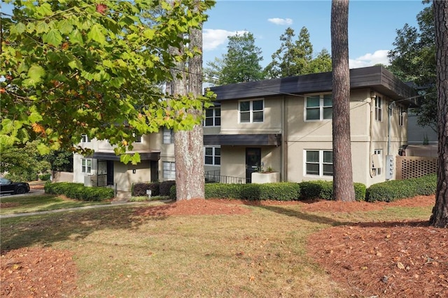 view of front facade featuring stucco siding and a front yard