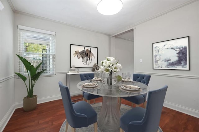 dining room with baseboards, wood finished floors, and crown molding