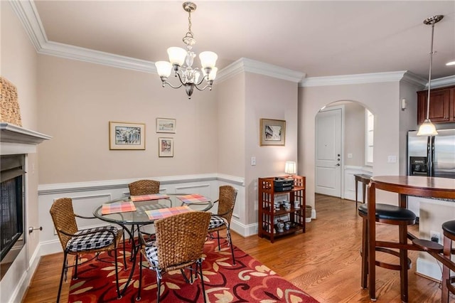 dining area featuring ornamental molding, a chandelier, and light hardwood / wood-style floors