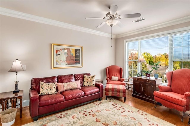 living room with ornamental molding, ceiling fan, and light hardwood / wood-style flooring