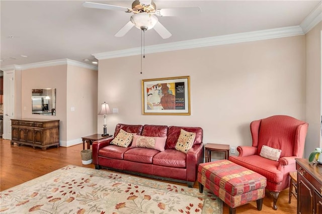 living room featuring ornamental molding, light hardwood / wood-style floors, and ceiling fan