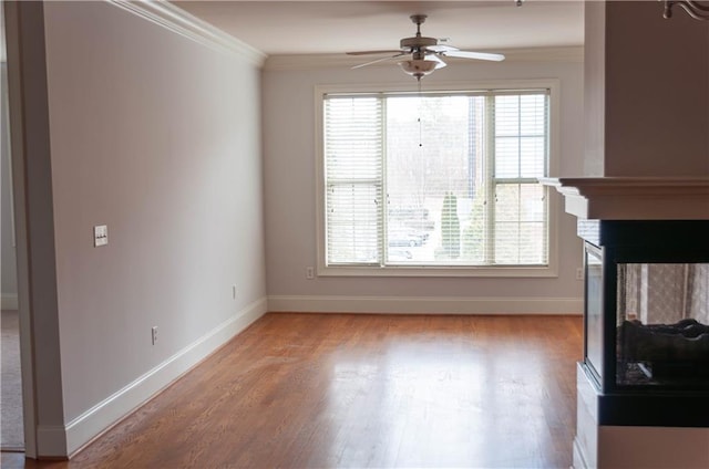 unfurnished living room featuring crown molding, a multi sided fireplace, ceiling fan, and light hardwood / wood-style flooring