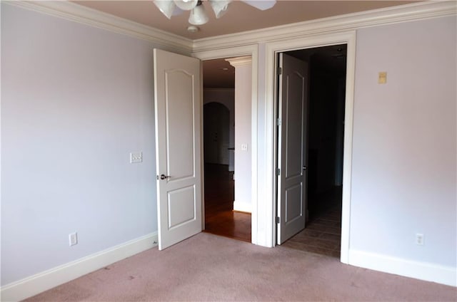 unfurnished bedroom featuring crown molding, ceiling fan, and carpet flooring