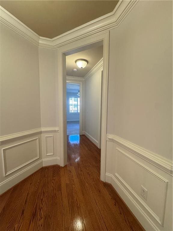 hall featuring a wainscoted wall, ornamental molding, and wood finished floors