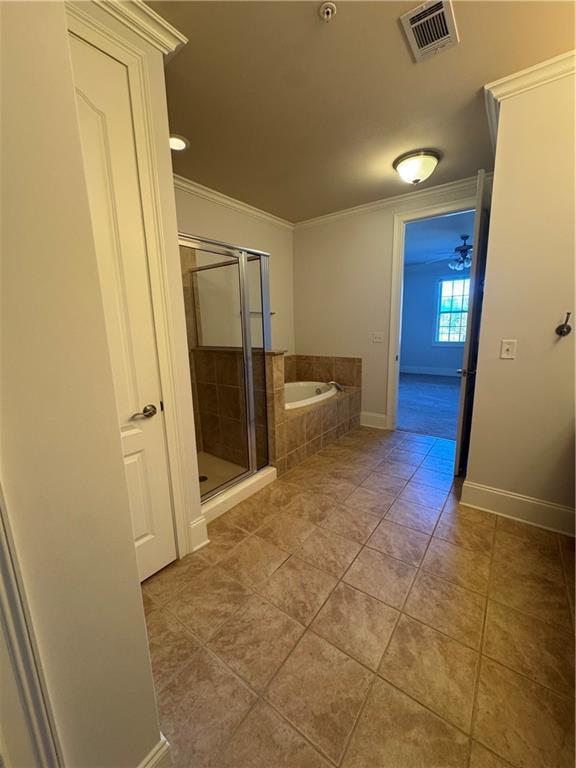 full bathroom with tile patterned flooring, visible vents, a bath, a stall shower, and crown molding
