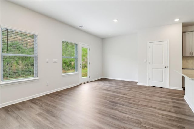unfurnished living room with baseboards, visible vents, recessed lighting, and wood finished floors