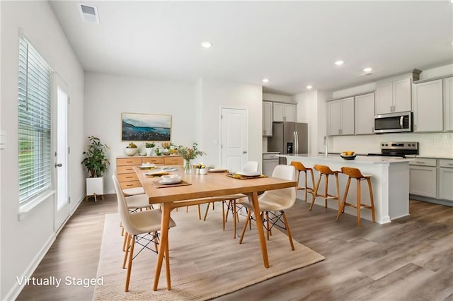 dining space featuring a wealth of natural light, light wood finished floors, and recessed lighting