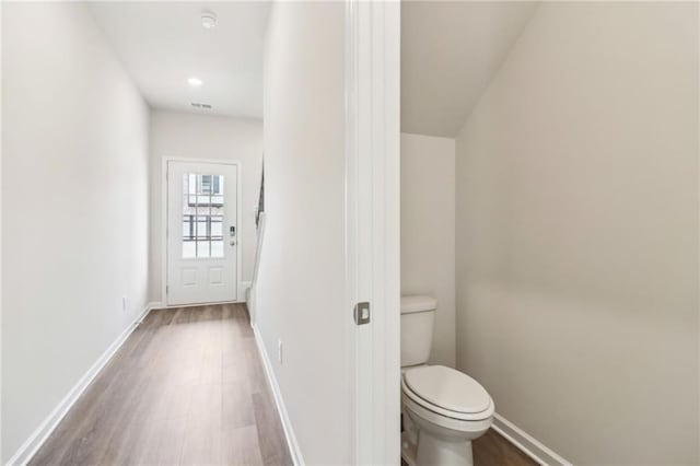 bathroom with toilet, baseboards, visible vents, and wood finished floors