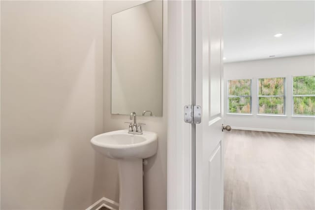 bathroom with recessed lighting, baseboards, and a sink