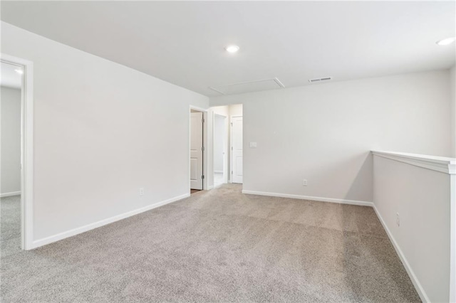 carpeted empty room with attic access, visible vents, baseboards, and recessed lighting