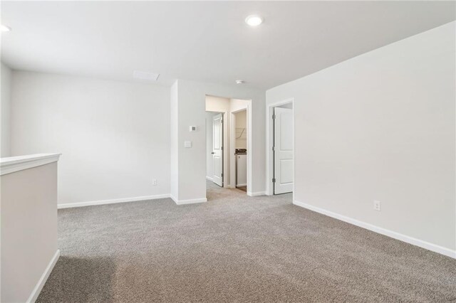 carpeted spare room featuring baseboards and recessed lighting