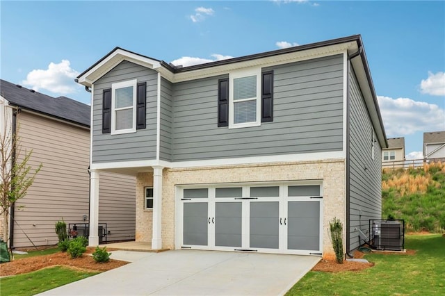 view of front of house featuring an attached garage, driveway, a front lawn, and central air condition unit