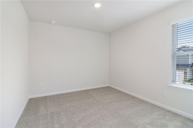 empty room featuring a wealth of natural light, baseboards, and carpet floors
