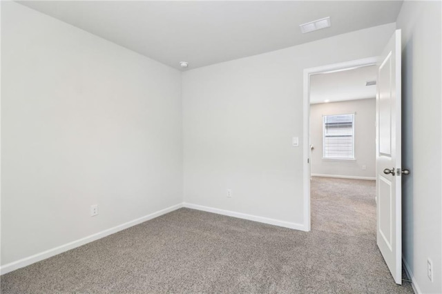 carpeted spare room with baseboards and visible vents