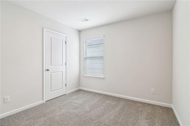 carpeted empty room featuring visible vents and baseboards
