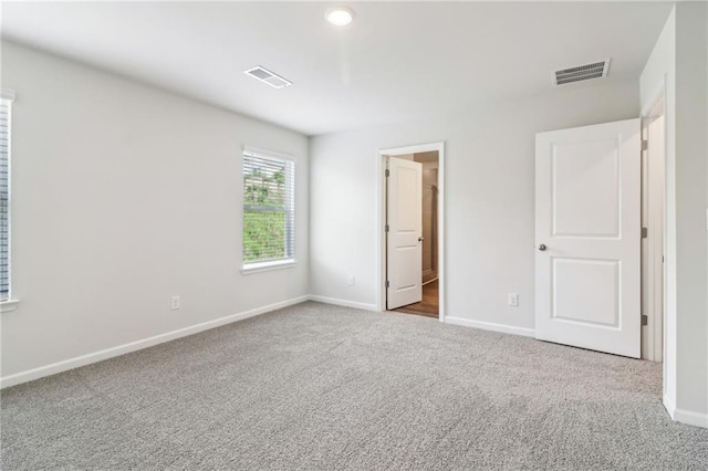 unfurnished bedroom featuring carpet floors, baseboards, and visible vents